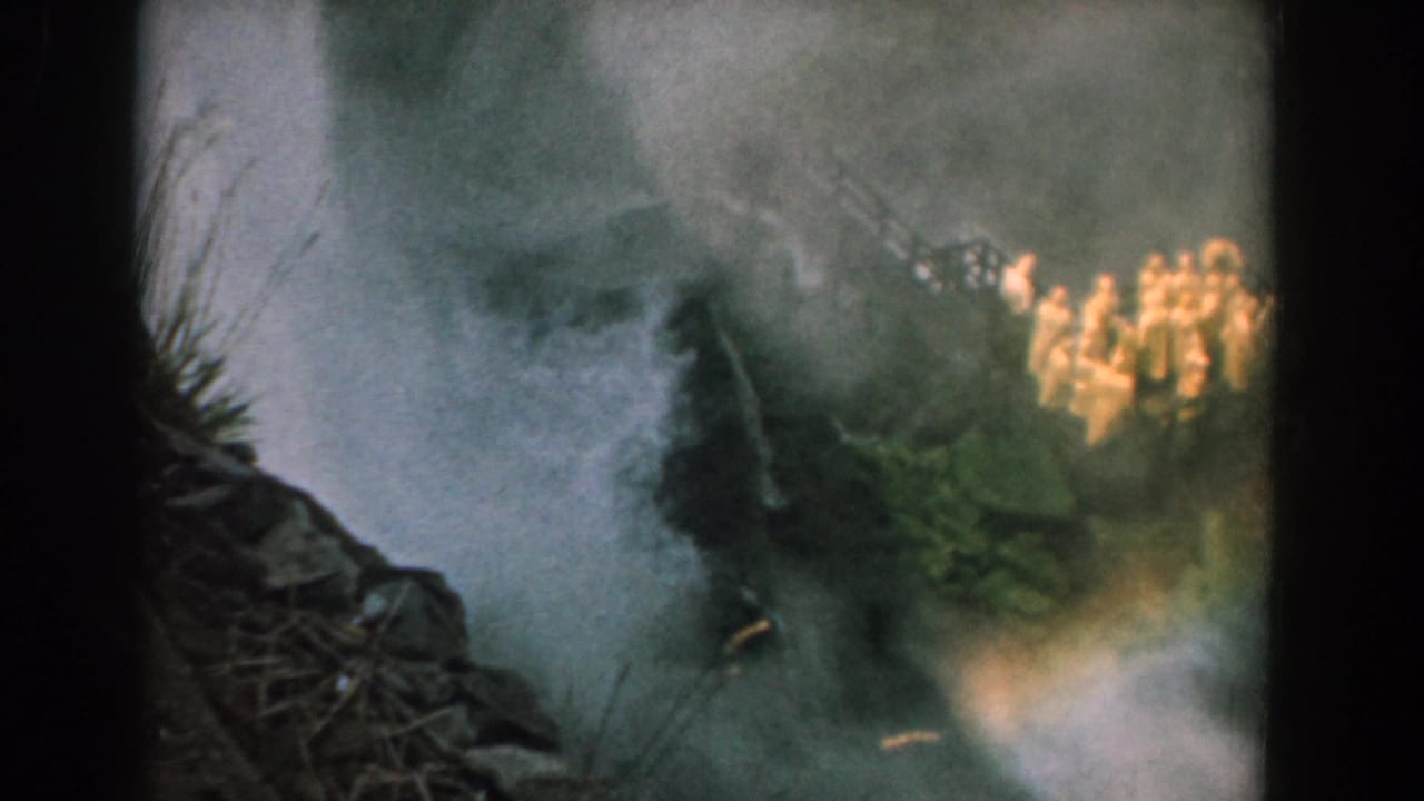 Water spray and mist rising over dark rocks near the shore.