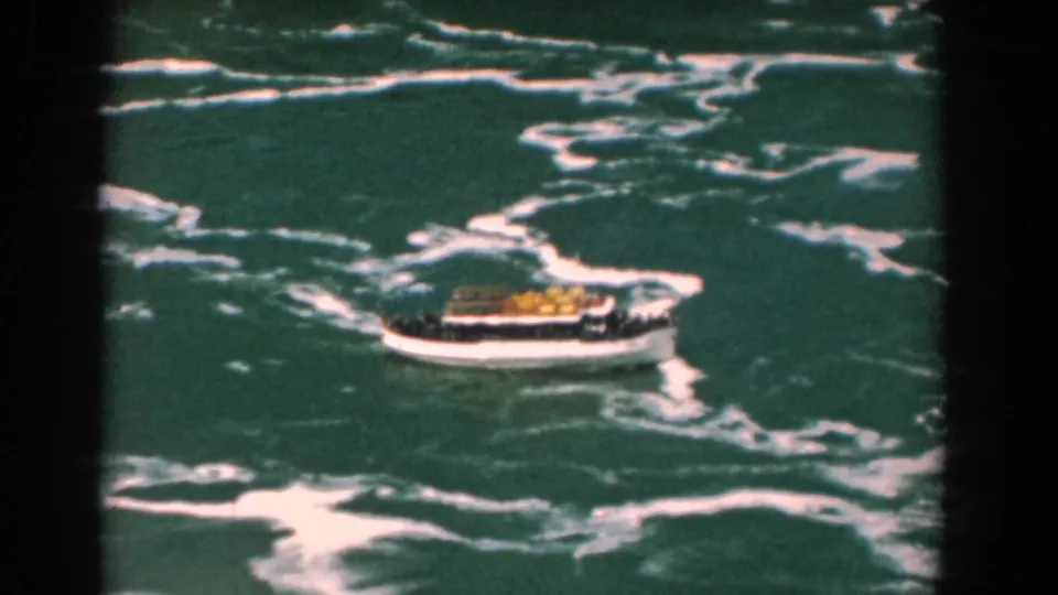 The white sightseeing boat continues through rough, foamy water in the 1958 Yorktown home-movie sequence.