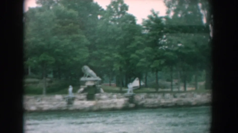 Yorktown, Virginia waterfront in 1958 with a lion sculpture, small statues, trees, and water filmed from a passing boat.