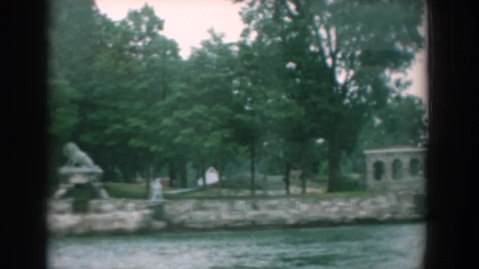 1958 boat-view frame of the Yorktown waterfront, with the lion sculpture partly at left and an arched structure among trees.