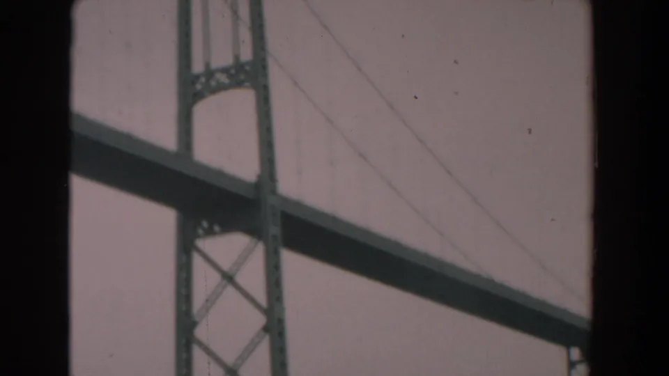 1958 Yorktown-area river footage ending on a close view of a steel suspension bridge structure against the sky.
