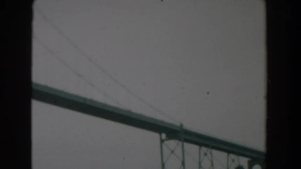 1958 Yorktown, Virginia home-movie frame showing a large green steel bridge behind dark film or window borders.