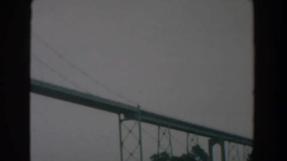 1958 home-movie still of a large green bridge near Yorktown, with structural supports visible beneath the deck.