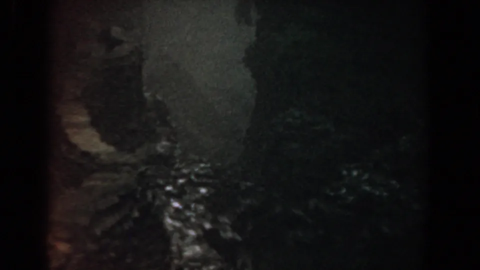 The final frame shows a shadowed stream area with rocks and faint water reflections in the same home-movie sequence.