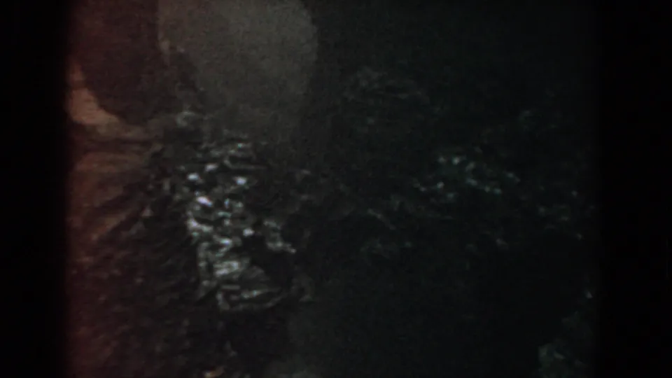 Yorktown, Virginia 8mm footage showing shadowed vegetation and glistening water or wet rock along a rough riverside area.