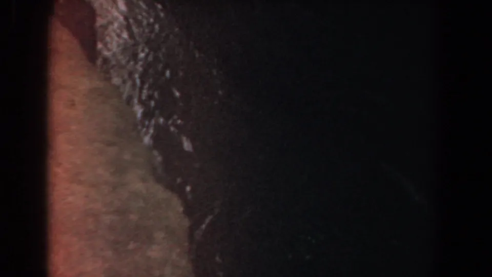 Close 1958 Yorktown view of water slipping over reddish-brown rock with deep shadow to the right.