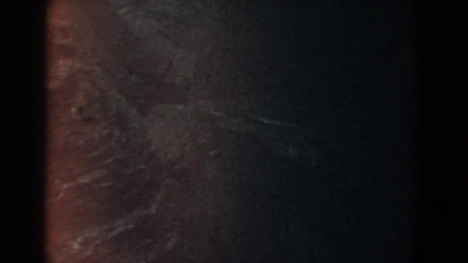 A dark 1958 8mm aerial-style view near Yorktown, Virginia, with brown and green terrain textures and obscuring grain.