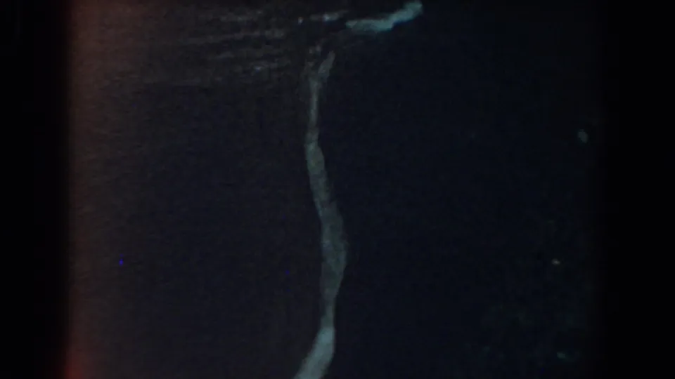 1958 Yorktown 8mm footage showing a slender waterfall and dark, wet rock texture.