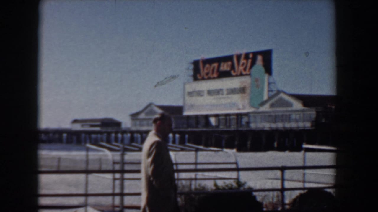 Yorktown, Virginia boardwalk scene showing a suited man near waterfront railings and a prominent Sea and Ski sign on the pier.