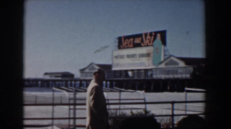 Yorktown, Virginia boardwalk scene showing a suited man near waterfront railings and a prominent Sea and Ski sign on the pier.