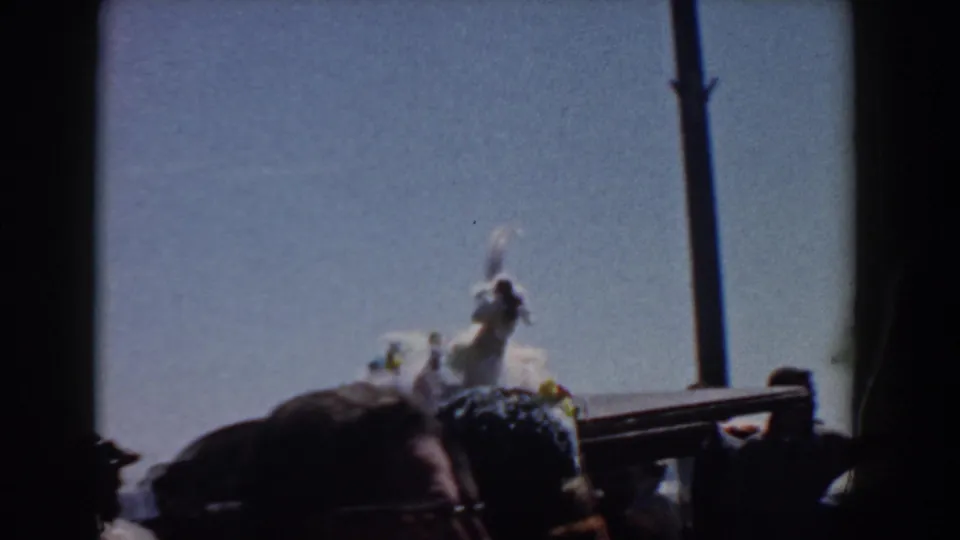 The homecoming parade figure appears to wave from a decorated vehicle or float as spectators watch in Yorktown, Virginia.