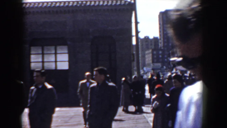 The final frame looks down a busy sidewalk beside a stone building, with pedestrians in coats and hats and a close foreground figure at right.