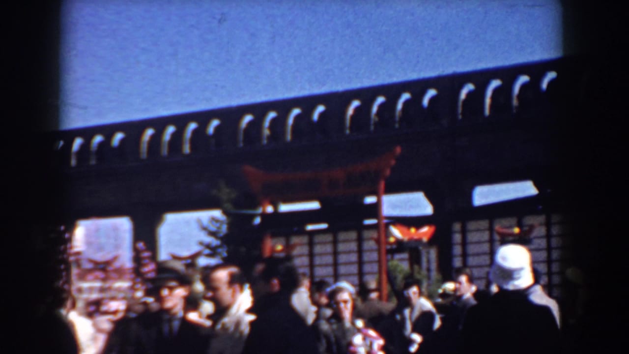 A Yorktown 1958 crowd moves beneath a Japanese-style torii and wooden structure during an outdoor cultural-themed gathering.