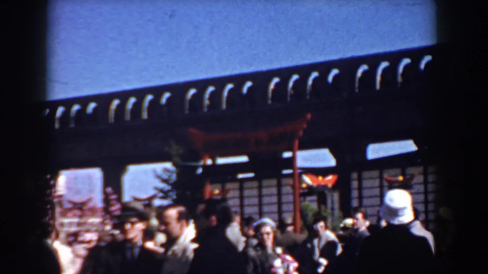 A Yorktown 1958 crowd moves beneath a Japanese-style torii and wooden structure during an outdoor cultural-themed gathering.