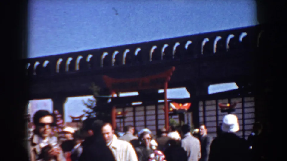 Adults in mid-century coats and hats pass through a crowded Yorktown event space with a Japanese-style torii overhead.