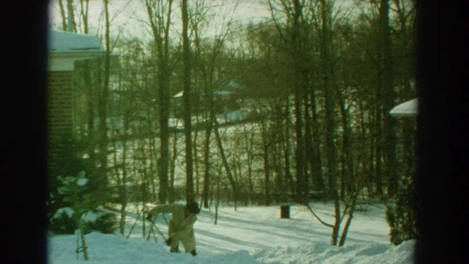 In the final frame, the man with a shovel stands on the snowy path near bare trees and the edge of a brick house.