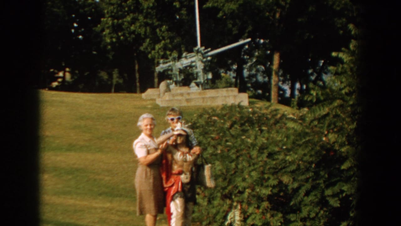 In a 1959 Florida park scene, two women stand with a child near shrubs while an artillery piece sits on a concrete base behind them.