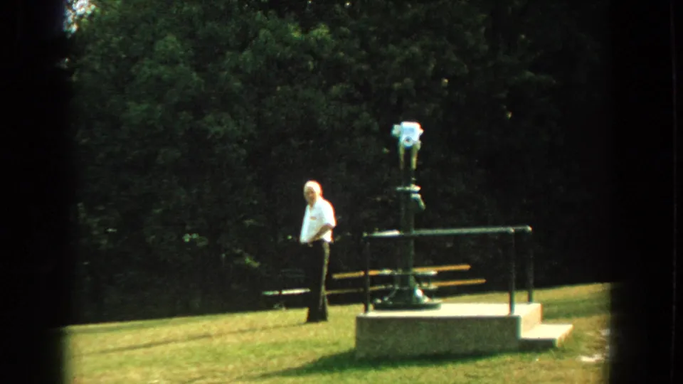 Near the end of the Florida park shot, the man in a white shirt stands closest to the mounted viewer while the suited man remains left.