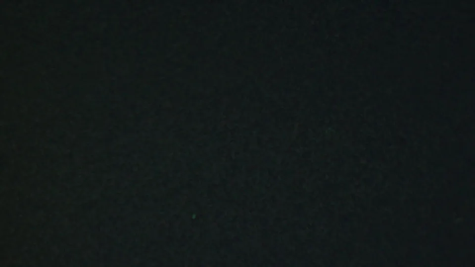 The final 1959 Paramus frame remains very dark, preserving only slight texture from the shaded setting and film grain.