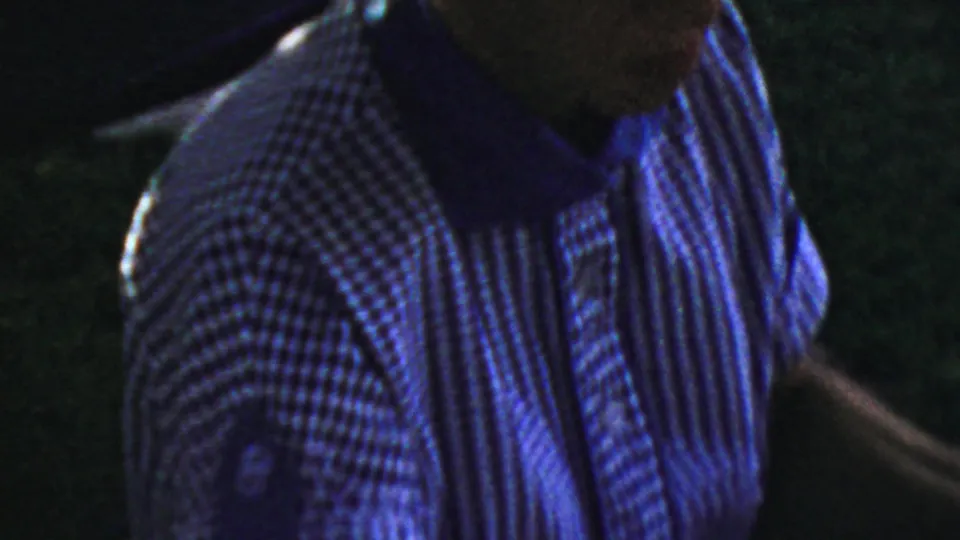 1959 Paramus home-movie frame showing an adult in a striped shirt seated near the meal table, with the face mostly shadowed.