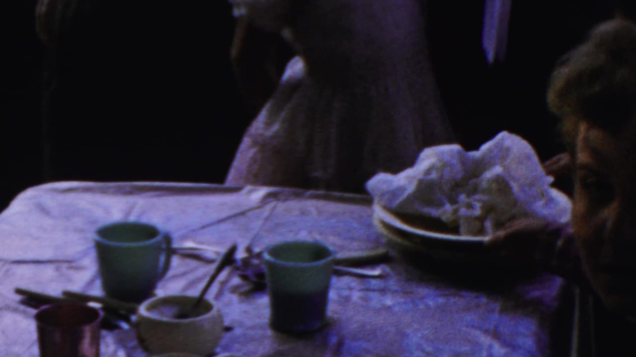 Paramus, New Jersey 1959 home-movie frame showing used dishes, green cups, and people near a post-meal table.