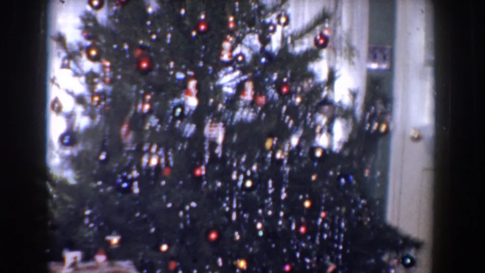 1960 Bel Air, Maryland holiday interior showing a decorated Christmas tree with shiny ornaments, tinsel, curtains, and a door at the side.