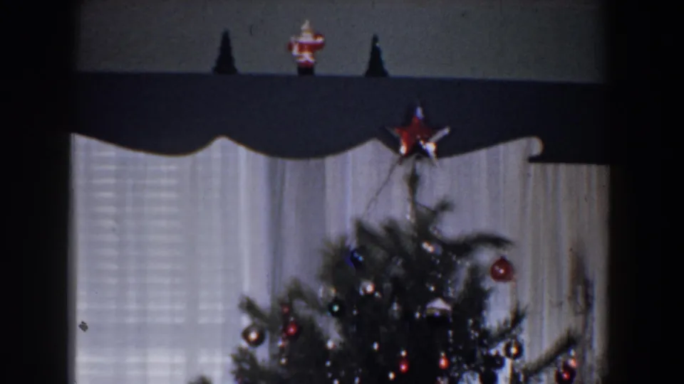 1960 Bel Air, Maryland interior view of the upper Christmas tree, red star topper, ornaments, window blinds, curtains, and dark valance.