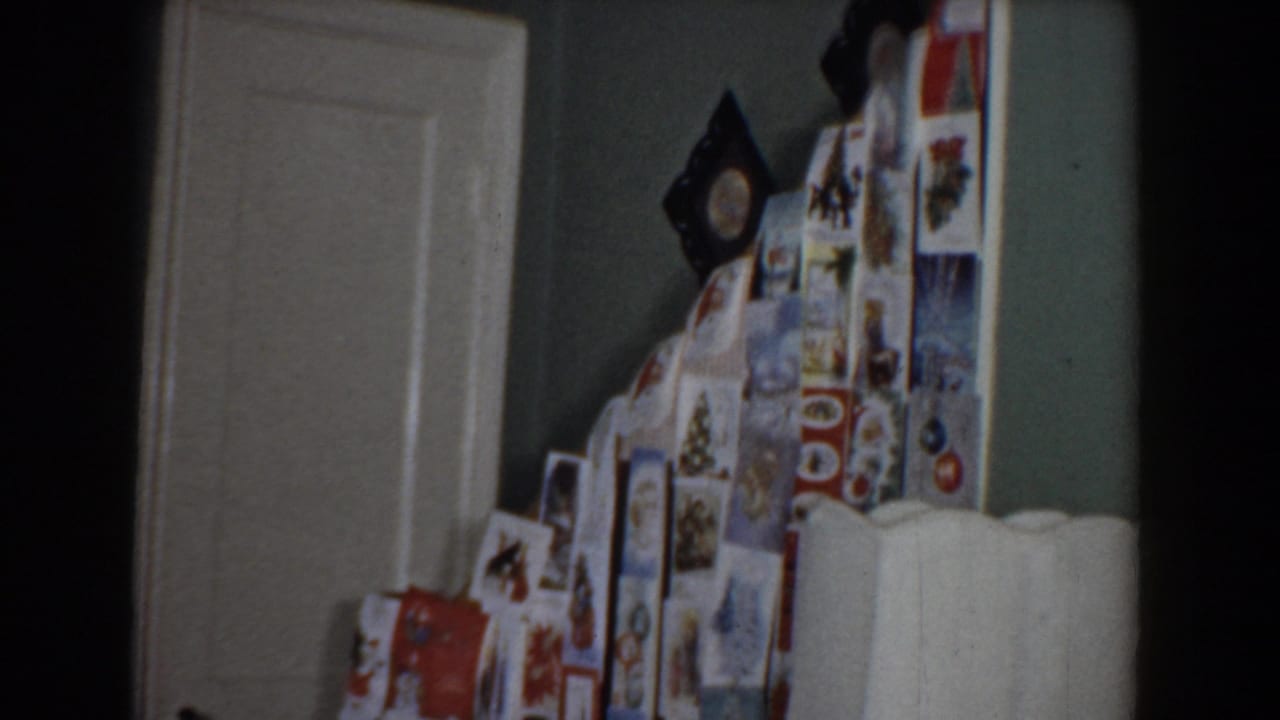 Kitchen view with refrigerator covered in photos or magnets beside a doorway.