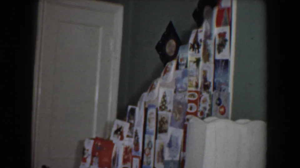 1960 Bel Air, Maryland home-movie frame showing a kitchen refrigerator with photos or magnets, a doorway, and partial view of the room.