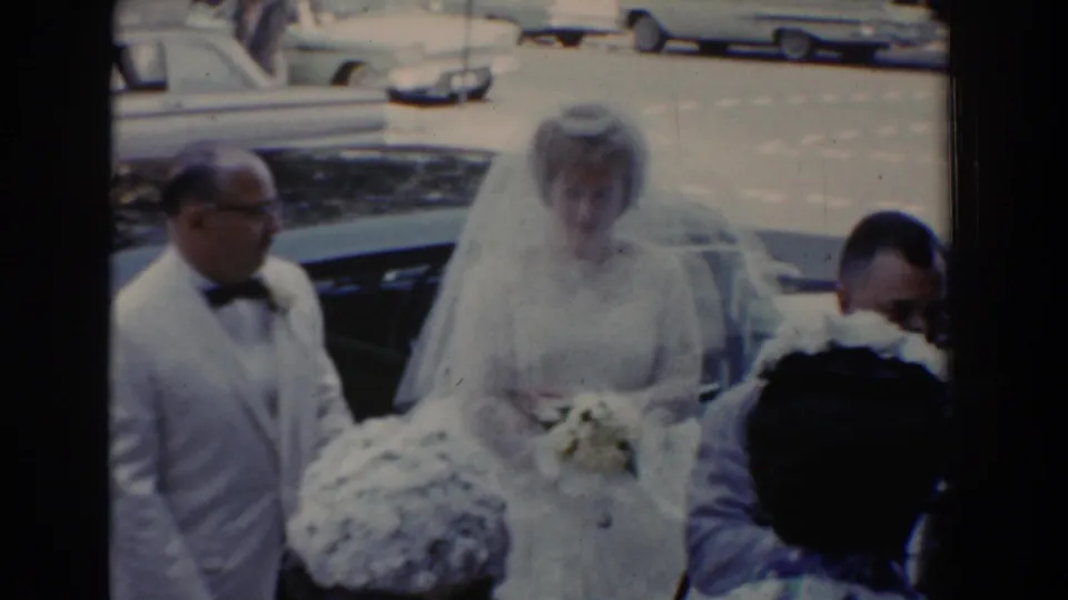 The bride stands near the open car area in Bel Air, Maryland, surrounded by wedding guests in formal attire.