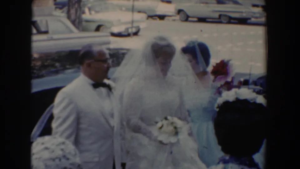 A 1960 wedding party moment shows the bride with bouquet, her father, and a blue-dressed bridesmaid beside parked cars.