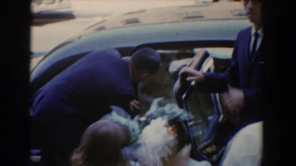 At the end of the Bel Air wedding moment, a man bends toward an open car door while the bride is partly visible inside.