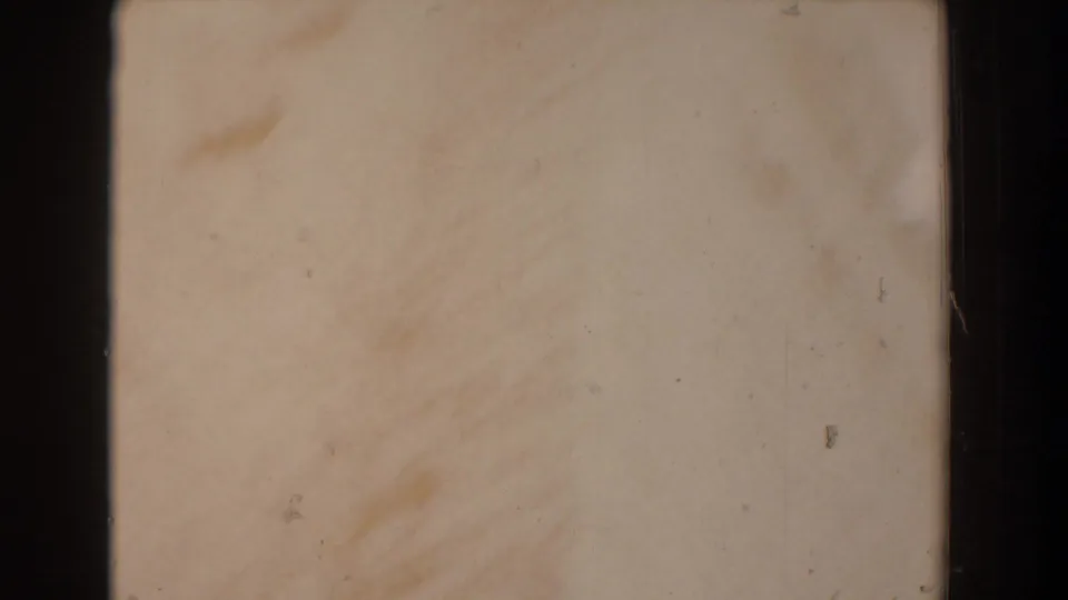 A pale, overexposed 8mm frame interrupts the wedding footage, with only faint film texture and marks visible.