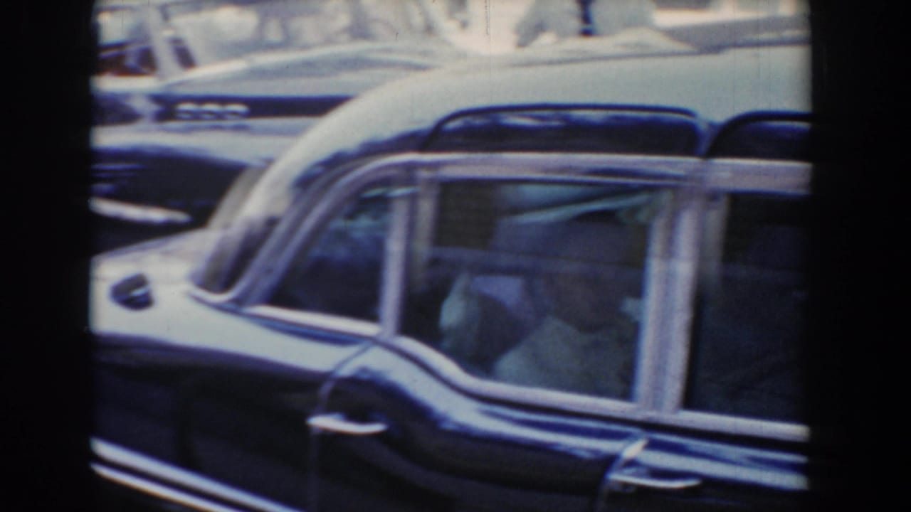 1960 Bel Air, Maryland 8mm frame showing a dark vintage station wagon with passengers visible through side windows.