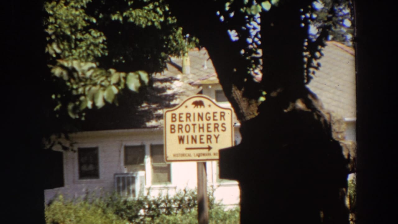 Beringer Brothers Winery sign partly framed by dark trees beside a pale building.