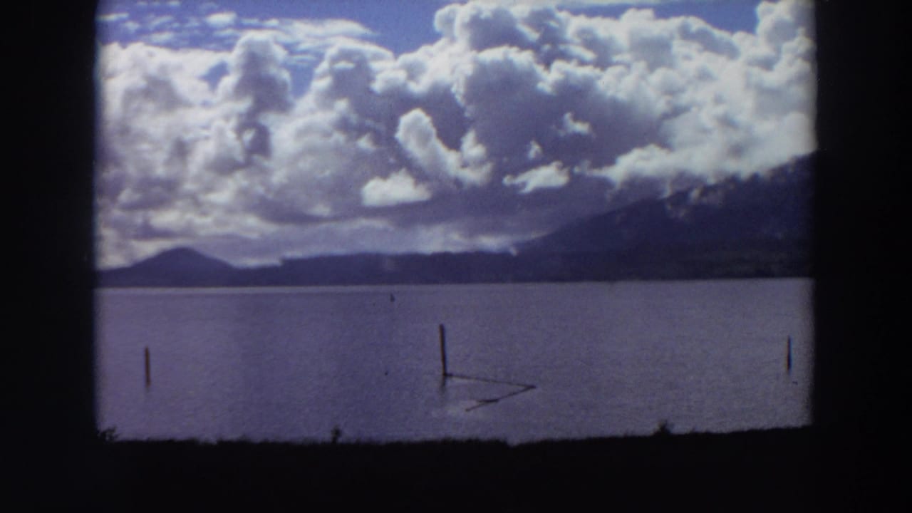 Lake and mountain horizon under heavy clouds, seen through dark 8mm frame borders.