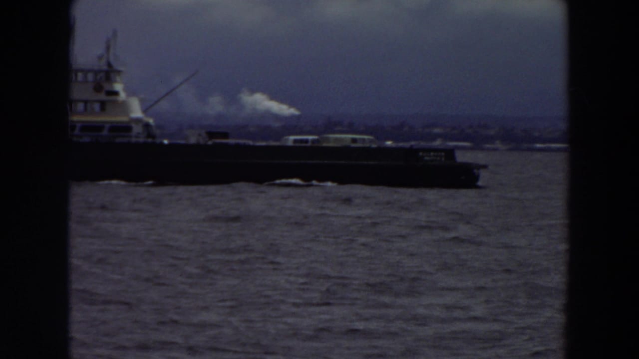 Large vessel crossing water under a cloudy sky.