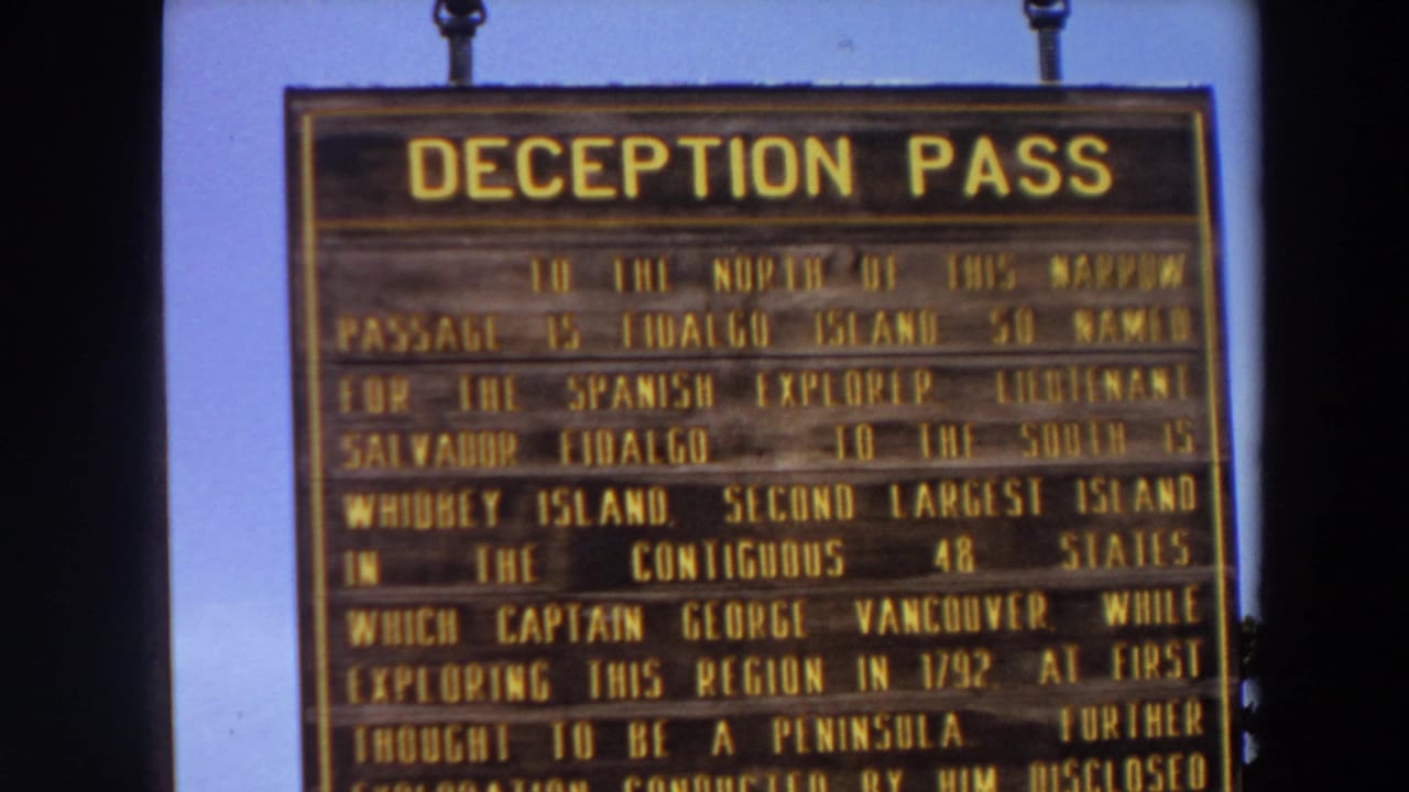 Deception Pass sign with several lines of yellow historical text visible.