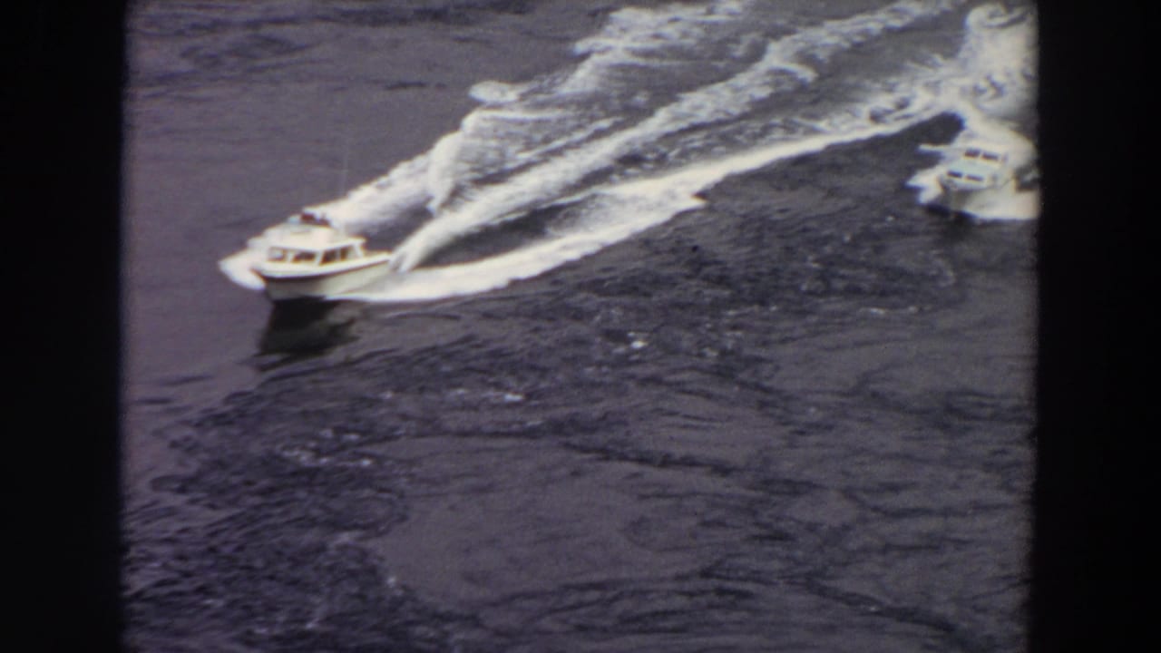 1964 Washington frame of two speedboats on open water, with the nearer boat leaving a strong white wake.