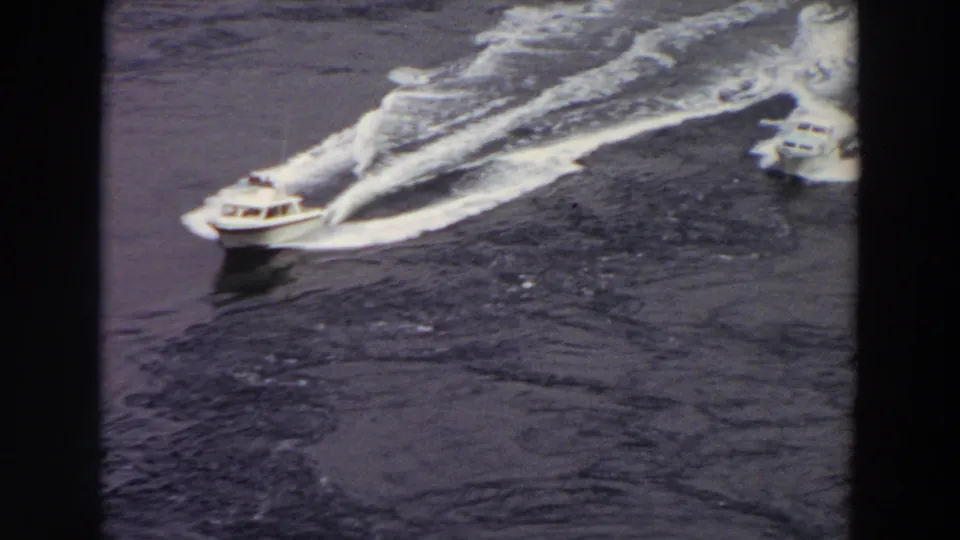 1964 Washington frame of two speedboats on open water, with the nearer boat leaving a strong white wake.