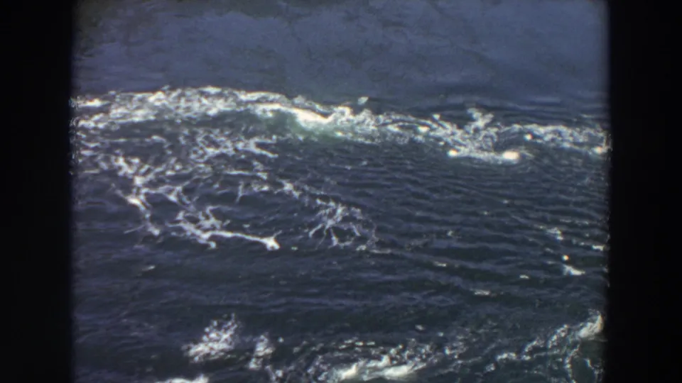 1964 Washington home-movie frame showing river rapids, swirling white foam, and dark water within visible 8mm borders.