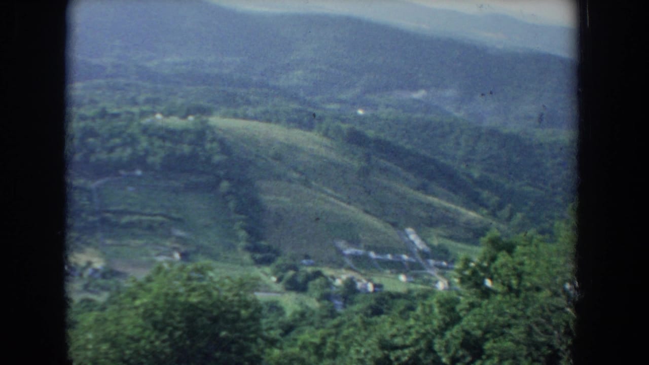 Wooded valley with rolling hills, fields, scattered homes, and dark 8mm frame borders.