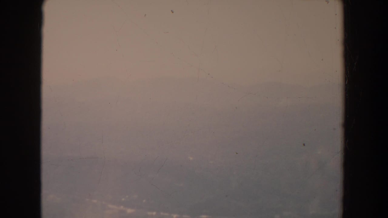Muted foggy horizon framed by a dark vertical window bar.