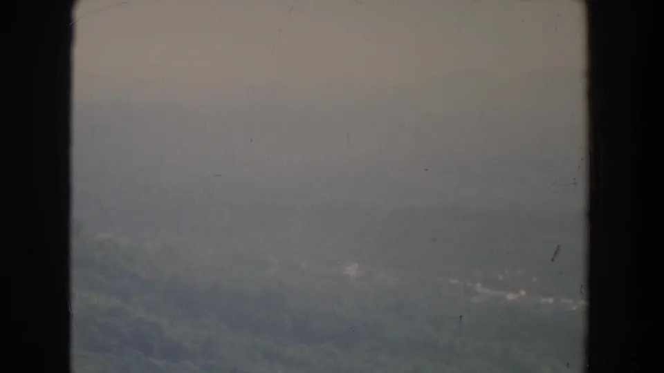 1965 Fallston, Maryland frame with a soft, hazy view over forested terrain and faint mountain contours.