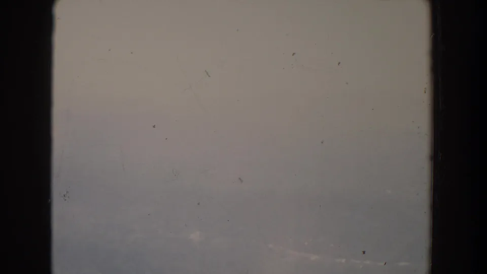 1965 Fallston, Maryland home-movie still showing a hazy landscape with faint valley forms and scratched 8mm texture.