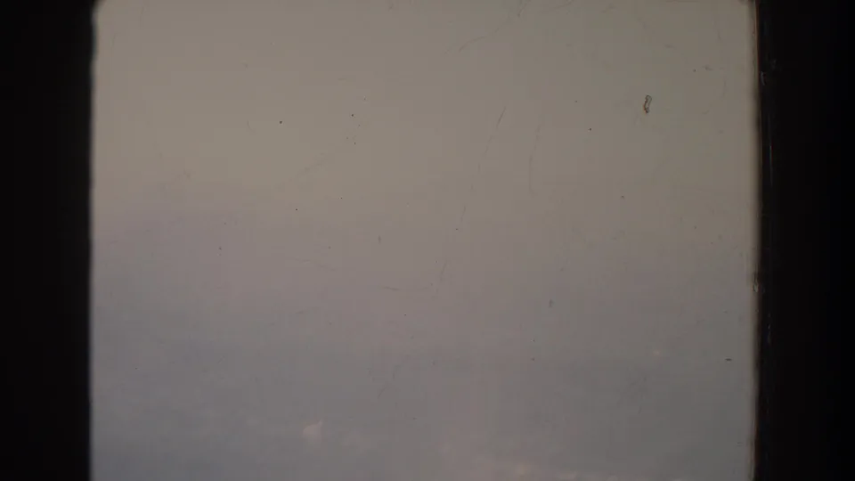 Late frame from 1965 Fallston, Maryland footage showing faint forested ridges through haze and visible small-gauge film wear.