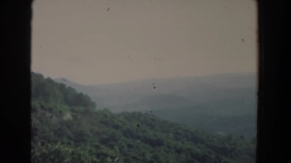 The frame shows a green wooded slope and a hazy valley beyond, consistent with the supplied 1965 Fallston, Maryland home-movie metadata.