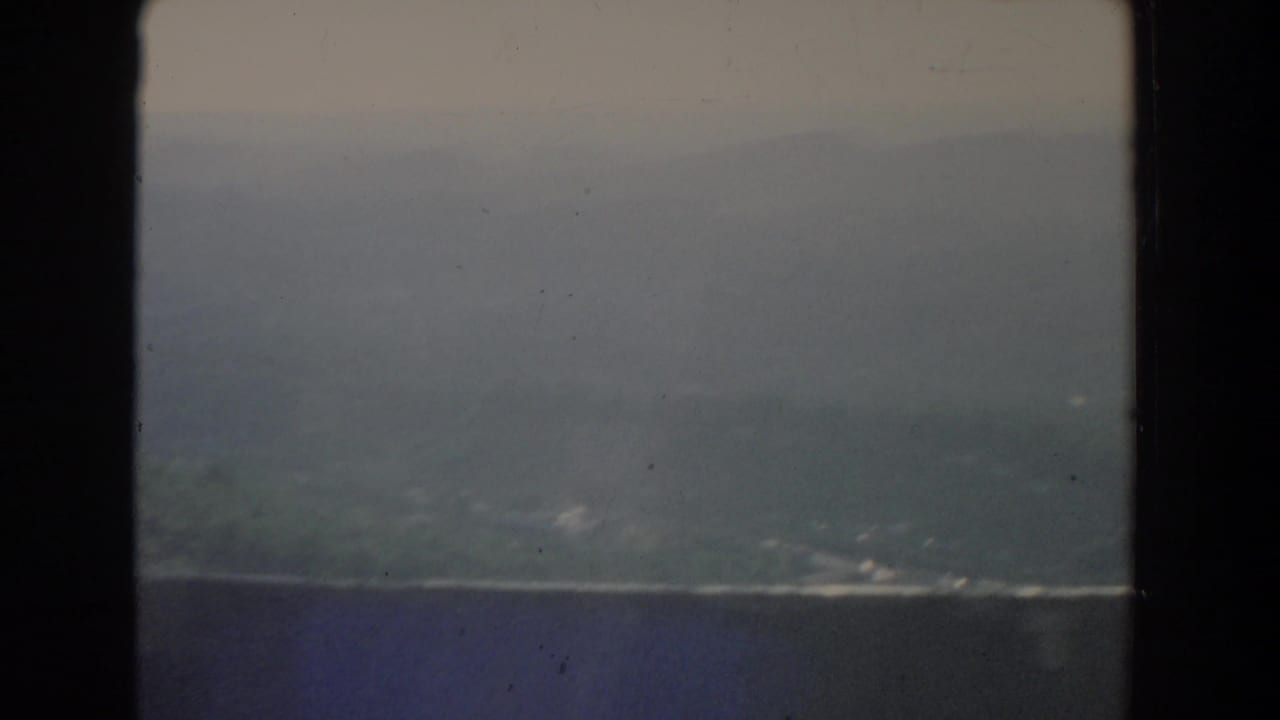 Distant hills and a dark horizontal band beneath a gray overcast sky.