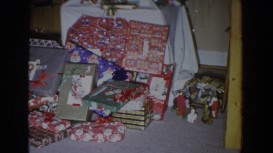 1965 Fallston, Maryland home interior showing wrapped Christmas gifts below the tree and a small nativity scene at the right edge.