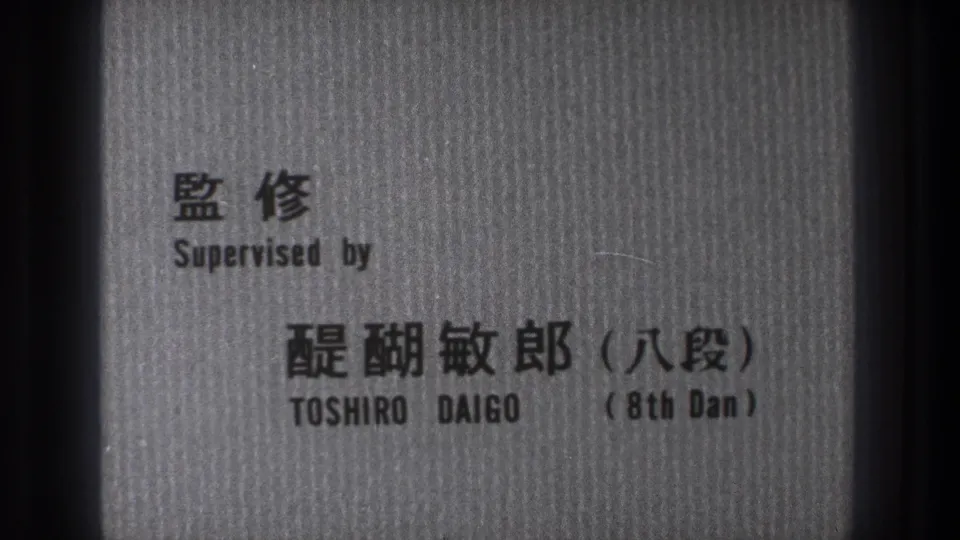 Monochrome credit card from the Tokyo judo film naming Toshiro Daigo as supervisor with Japanese text and an 8th Dan reference.